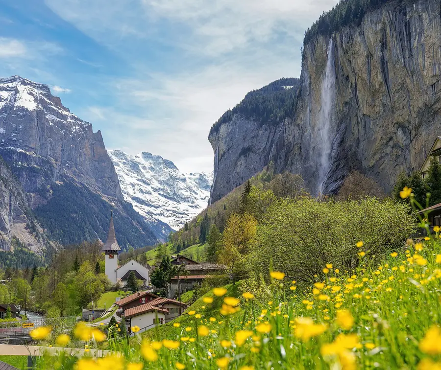 Lauterbrunnen church and the Staubbach falls over the valley cliffs